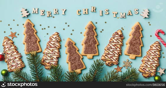 Merry Christmas written with wooden letters, cookies and Christmas decorations, flat lay