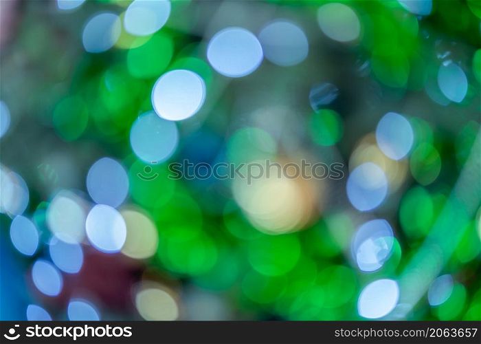 Merry x-mas,light Abstract circular bokeh of and Christmas greeting picture parcel decoration on Green Christmas tree background Decoration During Christmas and New Year.