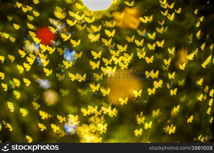 Merry x-mas,Yellow Colorful light Abstract butterfly bokeh of The light tunnel Christmas tree background Decoration During Christmas and Love New Year Festival illumination.