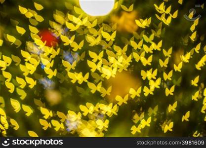 Merry x-mas,Yellow Colorful light Abstract butterfly bokeh of The light tunnel Christmas tree background Decoration During Christmas and Love New Year Festival illumination.