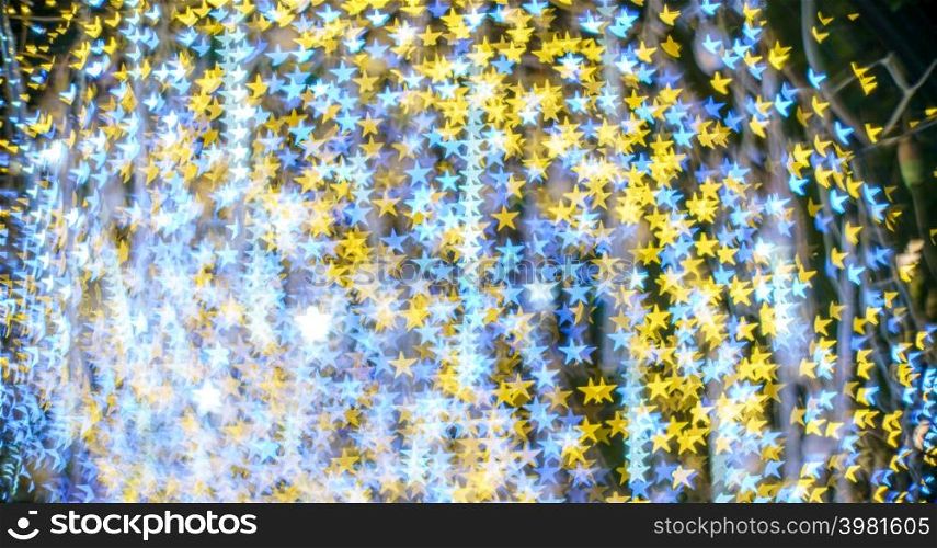 Merry x-mas,Yellow Colorful light Abstract star bokeh of The light tunnel Christmas tree background Decoration During Christmas and New Year Festival illumination.