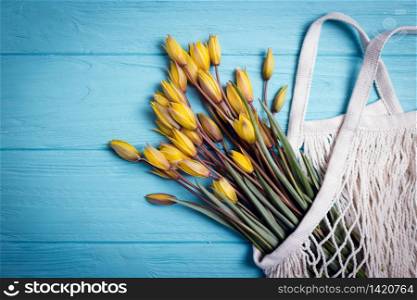 Mesh bag and sprigs of wild yellow tulips