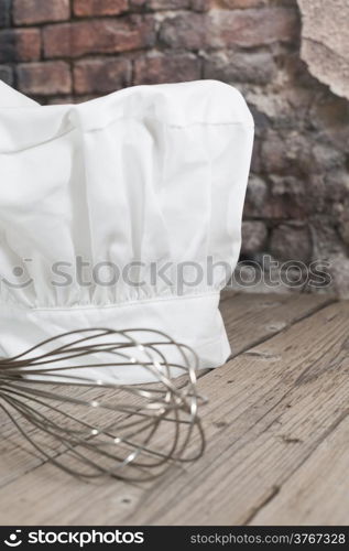 Mesh kitchen on a table next to a whisk