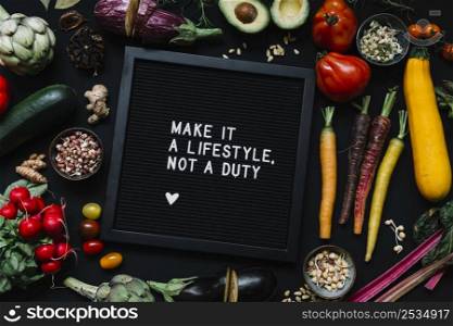 message black frame surrounded with vegetables against black backdrop