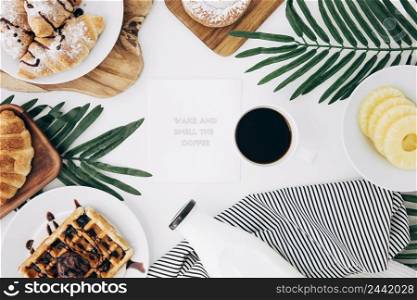 message notepad surrounded with baked breakfast coffee pineapple slices white desk