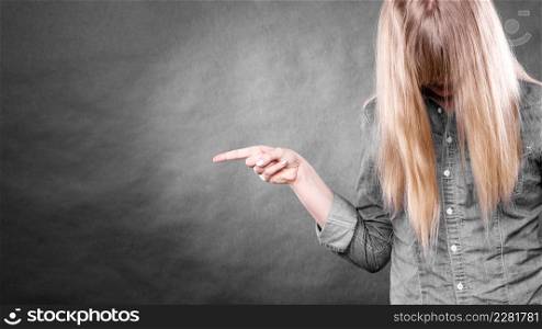 Messages and new information concept. Young blonde casual woman covering her face by hair. Girl showing presenting copy space.. Woman with covered face showing copy space.