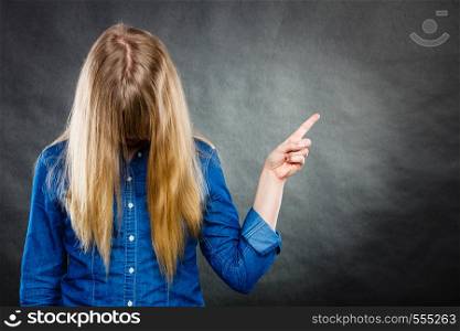 Messages and new information concept. Young blonde casual woman covering her face by hair. Girl showing presenting copy space.. Woman with covered face showing copy space.