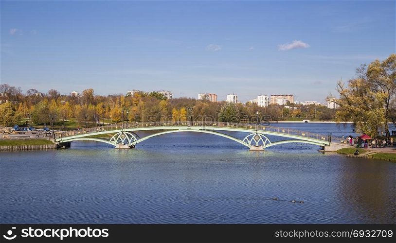Metal arch bridge across the pond. Moskyva. Tsaritsyno