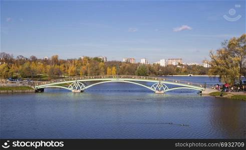 Metal arch bridge across the pond. Moskyva. Tsaritsyno