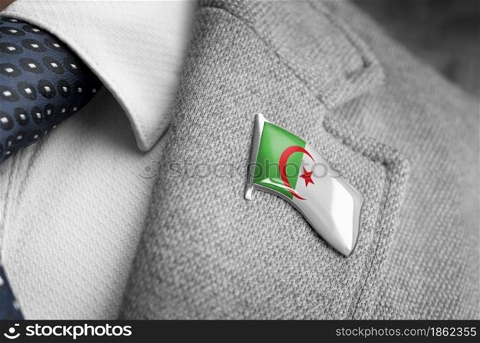 Metal badge with the flag of Algeria on a suit lapel.. Metal badge with the flag of Algeria on a suit lapel