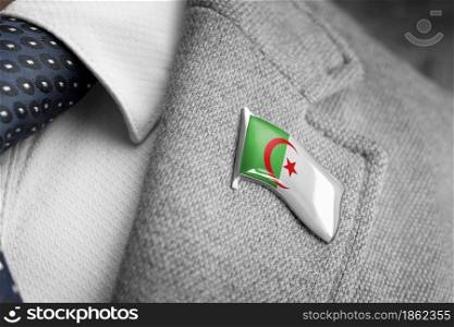 Metal badge with the flag of Algeria on a suit lapel.. Metal badge with the flag of Algeria on a suit lapel