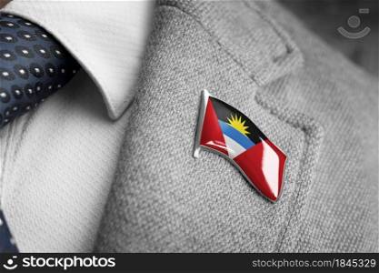 Metal badge with the flag of Antigua and Barbuda on a suit lapel.. Metal badge with the flag of Antigua and Barbuda on a suit lapel
