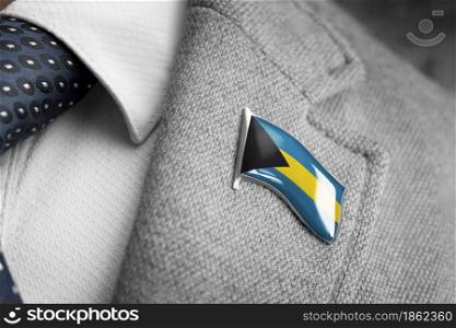 Metal badge with the flag of Bahamas on a suit lapel.. Metal badge with the flag of Bahamas on a suit lapel