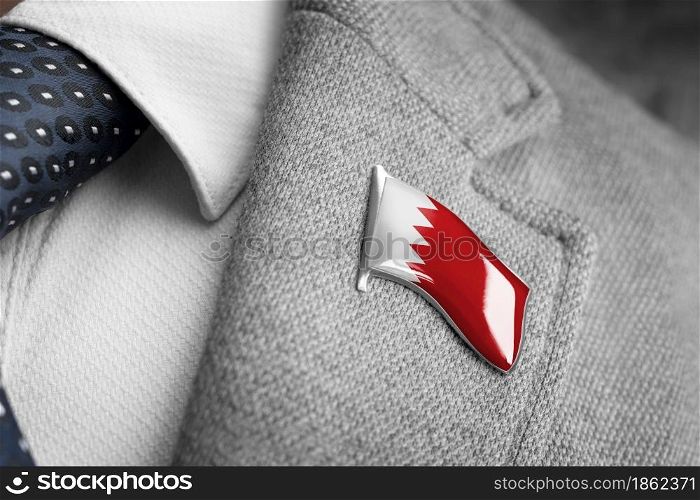 Metal badge with the flag of Bahrain on a suit lapel.. Metal badge with the flag of Bahrain on a suit lapel