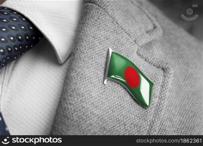 Metal badge with the flag of Bangladesh on a suit lapel.. Metal badge with the flag of Bangladesh on a suit lapel