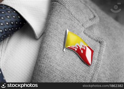 Metal badge with the flag of Bhutan on a suit lapel.. Metal badge with the flag of Bhutan on a suit lapel