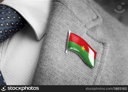Metal badge with the flag of Burkina Faso on a suit lapel.. Metal badge with the flag of Burkina Faso on a suit lapel