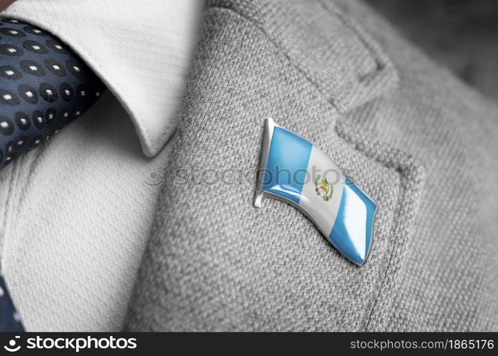 Metal badge with the flag of Guatemala on a suit lapel.. Metal badge with the flag of Guatemala on a suit lapel