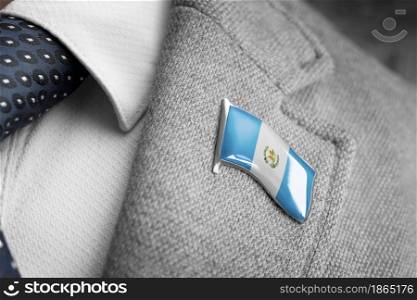 Metal badge with the flag of Guatemala on a suit lapel.. Metal badge with the flag of Guatemala on a suit lapel