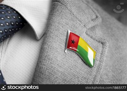 Metal badge with the flag of Guinea Bissau on a suit lapel.. Metal badge with the flag of Guinea Bissau on a suit lapel