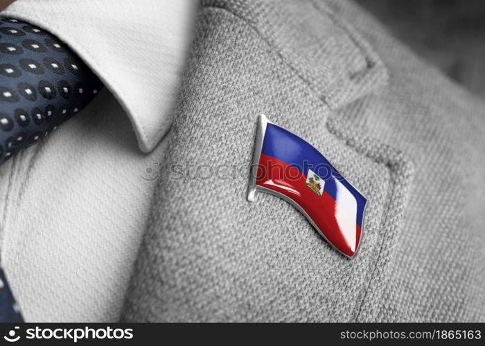 Metal badge with the flag of Haiti on a suit lapel.. Metal badge with the flag of Haiti on a suit lapel