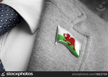 Metal badge with the flag of Wales on a suit lapel.. Metal badge with the flag of Wales on a suit lapel