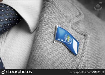 Metal badge with the flag of World Health Organization WHO on a suit lapel.. Metal badge with the flag of World Health Organization WHO on a suit lapel