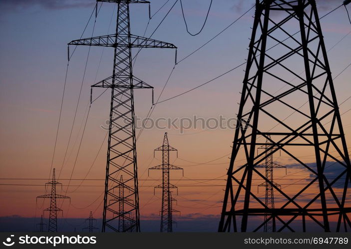 Metal Bearing high voltage power line at sunset. Metal Bearing high voltage power line at sunset.