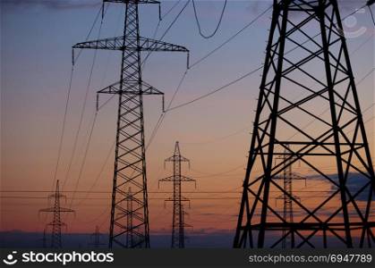Metal Bearing high voltage power line at sunset. Metal Bearing high voltage power line at sunset.