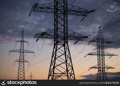 Metal Bearing high voltage power line at sunset. Metal Bearing high voltage power line at sunset.