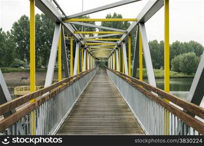 metal bridge crossing the river maas in holland