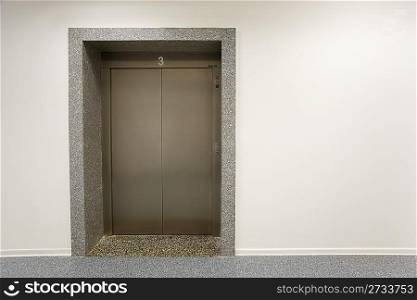 Metal door of elevator on third floor office building.