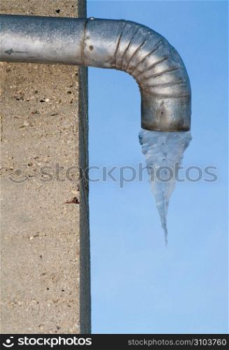 Metal drain pipe with frozen water underneath