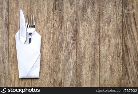 metal fork and knife on wooden table, with copy space