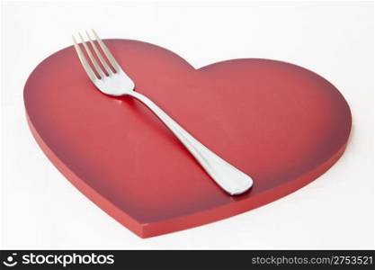 Metal fork on a valentine&rsquo;s heart