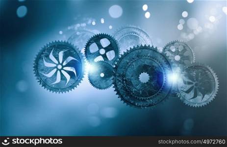 Metal gears and cogwheels. Mechanism of metal gears and cogwheels on blue background