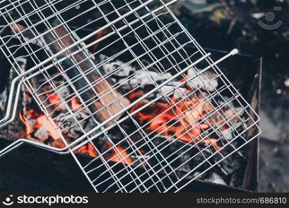 Metal grill on open fire. Cooking barbecue at picnic.