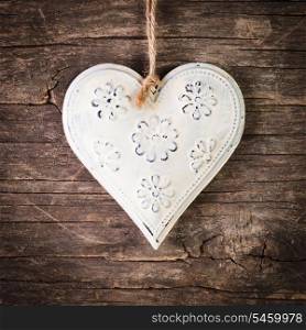 Metal heart on the shabby wooden background
