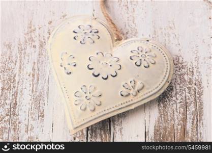 Metal heart on the shabby wooden background