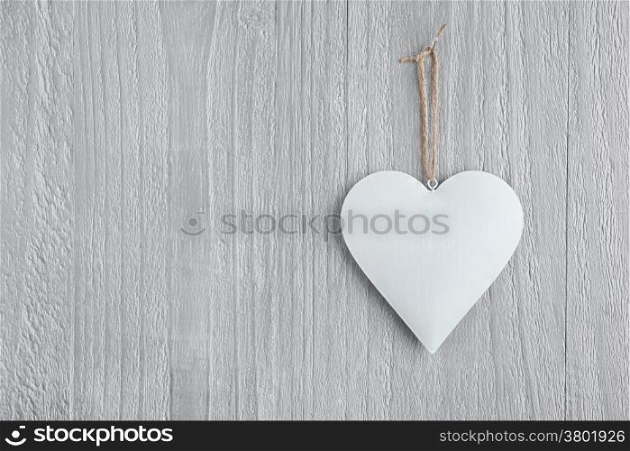 Metal heart on vintage wooden background as Valentines Day symbol