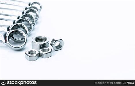 Metal hexagon nuts and chrome wrenches isolated on white background. Mechanic tools for maintenance. Hardware tool. Fastener with a threaded hole. Set chrome spanner wrench and nuts. Silver wrenches.