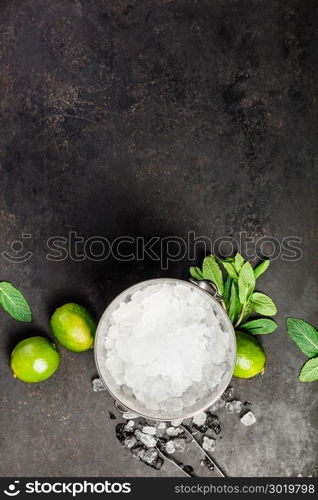 Metal ice bucket and mojito ingredients on dark background. Metal ice bucket and mojito ingredients