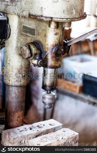 Metal industry stand with drill machine. Home workshop with hard tools on the metal stand. Old rusty hand tool drill machine on the metal stand. Metal industry stand with drill machine. Home workshop with hard tools on the metal stand. Old rusty hand tool drill machine on the metal stand.