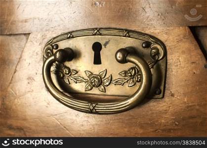 Metal ironmongery of drawer locker of antique wooden cabinet closeup