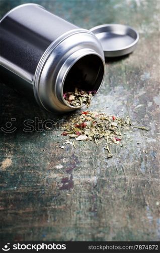 Metal jar with herbal tea on wooden table