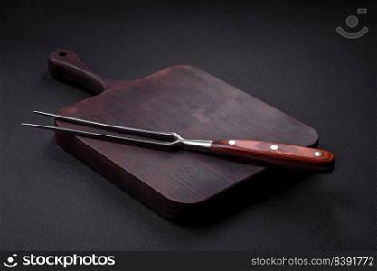 Metal kitchen fork on a dark textured concrete background. Cutlery, preparation for dinner