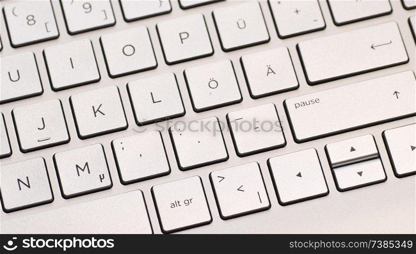 Metal laptop keyboard with german layout, macro shot with panning.. Metal laptop keyboard