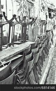 Metal Legged Bistro Chairs with Wooden Seats Stacked Outside a Bar in Israel City of Jaffa, Black and White Picture