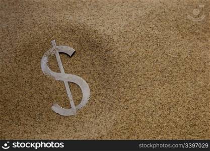 metal letterpress dollar type buried in desert sand - financial crisis concept