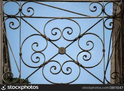 Metal ornament of old weathered city balcony on blue sky background